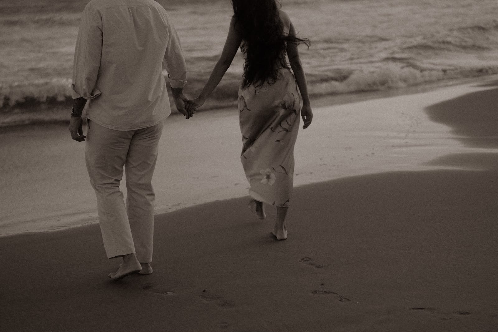 Sindhu and Amish walking hand in hand along the shore